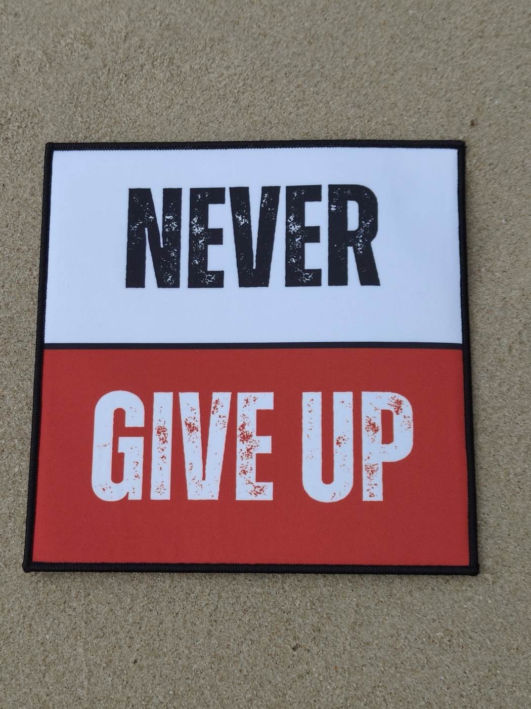 Real Never Give Up patch, photographed flat